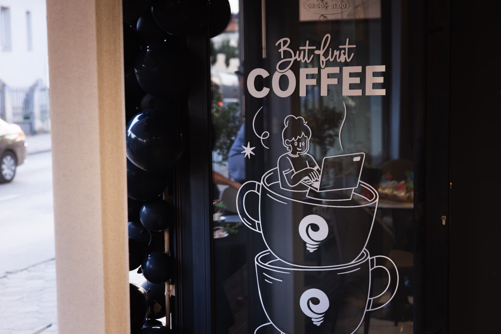 Close view of the but first coffee window graphic at ENO-AD Coffee