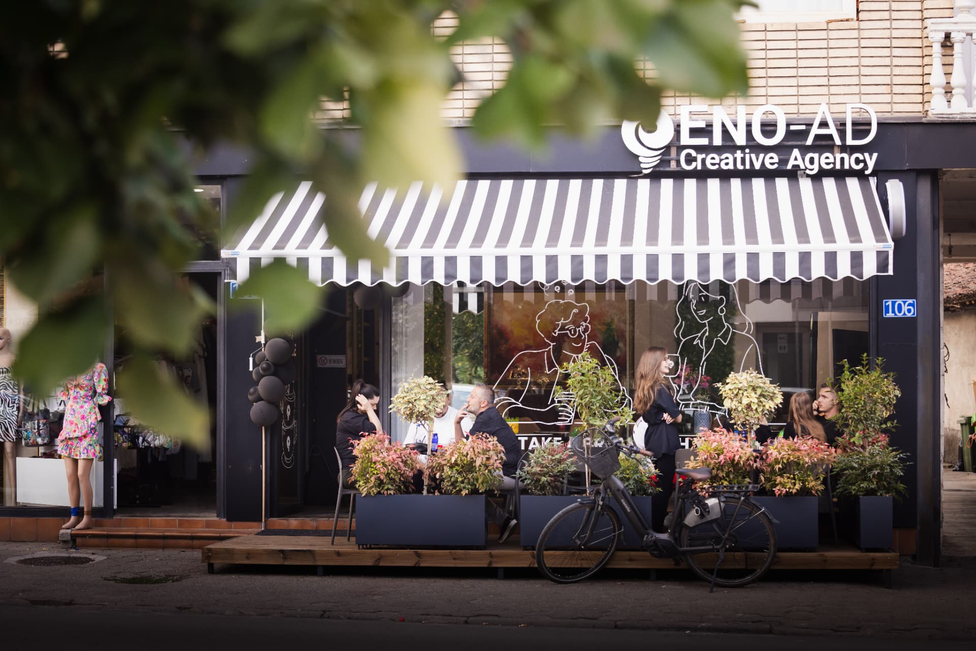 ENO-AD Coffee storefront on a sunny day with people at outdoor tables